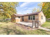 Brick ranch house with a concrete patio and driveway at 408 N Sherwood Dr, Muncie, IN 47304