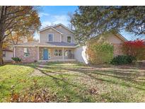 Two-story house with brick and siding, covered porch, and landscaped yard at 120 Walnut St, Southport, IN 46227