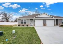 Newly constructed duplex with two-car garage and well-manicured lawn at 1442 Coen Ct, Columbus, IN 47201