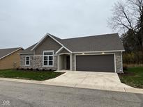 One-story home with stone and brown siding, two-car garage, and landscaped lawn at 4204 W Palomino Ct, Muncie, IN 47304