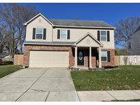 Two-story house with beige siding, brick accents, and a two-car garage at 7530 Redcliff Rd, Indianapolis, IN 46256