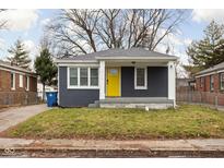 Gray brick house with yellow door, covered porch, and small front yard at 5114 Hillside Ave, Indianapolis, IN 46205
