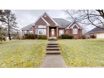 Brick ranch home with a spacious lawn and walkway at 9699 Prairiewood Way, Carmel, IN 46032