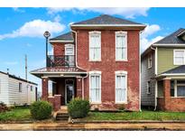 Brick two-story house with balcony, steps, and small front yard at 1726 S Meridian St, Indianapolis, IN 46225