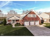 Brick home with two-car garage and landscaped lawn at 11736 Grazing Ln, Indianapolis, IN 46239