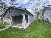 Gray house with a front porch and small yard at 4102 Spann Ave, Indianapolis, IN 46203