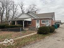 Charming brick ranch home with covered front porch and fenced yard at 715 W Main St, Plainfield, IN 46168