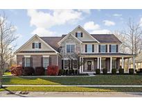 Two-story brick home with large front porch and landscaping at 7534 Sedge Meadow Dr, Indianapolis, IN 46278
