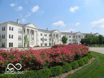 White building exterior with landscaping and rose bushes at 12938 University Cres # Apt 2B, Carmel, IN 46032