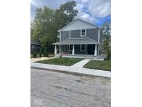 Two-story gray house with white accents, front porch, and landscaped yard at 1826 N Dexter St, Indianapolis, IN 46202