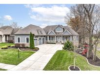 Gray exterior boasts a three-car garage and well-manicured landscaping at 4411 Miller Way, Westfield, IN 46062