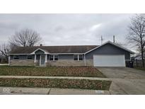 Gray house with stone accents, attached garage, and a well-maintained lawn at 46 Crestview Dr, Greenwood, IN 46143