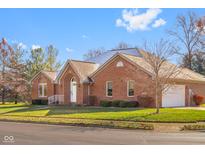 Brick ranch house with a white door, attached garage, and manicured lawn at 5059 Countess Dr, Columbus, IN 47203