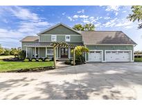 Green two-story house with a large driveway and attached garage at 5765 W 100 N, Greenfield, IN 46140