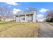 Gray ranch house with a spacious yard, attached garage, and long driveway at 6104 W Elaine St, Indianapolis, IN 46224