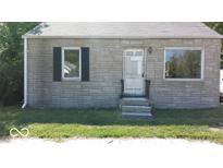 Tan brick ranch home with dark shutters, white door, and small front yard at 3716 N Emerson Ne Ave, Indianapolis, IN 46218