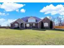 Brick home with large windows, a stone accent, and a well-manicured lawn at 11262 N Everett Rd, Monrovia, IN 46157