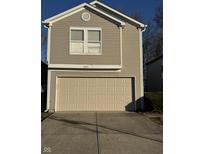 Tan two-story house with a beige garage door and a small front yard at 5283 Tufton Dr, Indianapolis, IN 46254