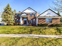 Brick two-story house with white accents, a large front yard, and a paved walkway at 8265 Plumwood Ln, Indianapolis, IN 46256