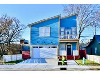 Stunning two-story blue house with a white garage door and landscaped lawn at 2318 E Brookside Ave, Indianapolis, IN 46218