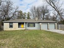 Ranch home with stone exterior, attached two-car garage, and landscaped lawn at 3206 W 57Th St, Indianapolis, IN 46228