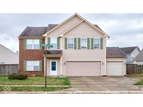Two-story house with brick and beige siding, two-car garage, and landscaped yard at 8231 Golden Ridge Ln, Indianapolis, IN 46237