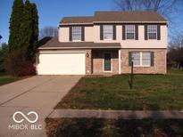 Two-story brick home with attached garage and landscaped lawn at 10604 Creekside Woods Dr, Indianapolis, IN 46239