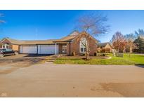 Brick ranch home with attached two-car garage and landscaped front yard at 1705 Cloister Dr, Indianapolis, IN 46260