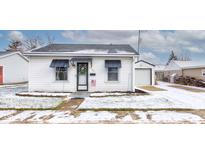 Charming white bungalow with snow-covered lawn and detached garage at 917 Garfield St, Lebanon, IN 46052