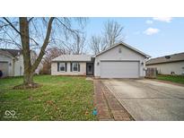 Ranch home with attached garage and landscaped lawn at 6369 River Valley Way, Indianapolis, IN 46221