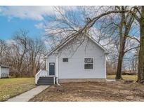 Front exterior of a gray two-story home with a small front porch and steps at 2709 Station St, Indianapolis, IN 46218