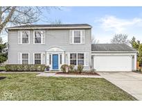 Gray two-story house with blue door, attached garage, and well-maintained lawn at 7330 Crickwood Pl, Indianapolis, IN 46268