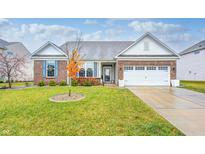 Brick ranch home with landscaped lawn, two-car garage, and charming curb appeal at 8885 River Ridge Dr, Brownsburg, IN 46112