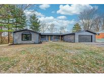 Ranch style home with gray siding, landscaping, and a two-car garage at 7244 Travis Rd, Greenwood, IN 46143