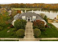 Luxury home with lake views and spacious grounds in autumn at 8804 Waterside Dr, Indianapolis, IN 46278