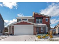 Two-story home with red and beige exterior, snow-covered lawn, and attached garage at 610 Atlas Dr, Lebanon, IN 46052