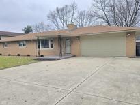 One-story home with attached garage, concrete driveway, and covered entryway at 117 N Elma St, Anderson, IN 46012