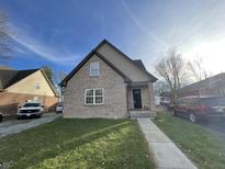 Charming two-story home with brick and siding exterior, front yard, and walkway at 6215 E 11Th St, Indianapolis, IN 46219