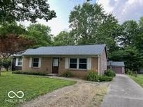 Brick ranch house with attached garage, new roof and landscaped yard at 6736 Carlsen Ave, Indianapolis, IN 46214