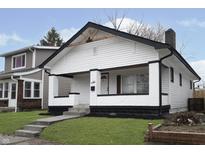 Charming white bungalow with black accents, steps, and a manicured lawn at 1127 E Kelly St, Indianapolis, IN 46203