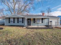 Ranch home with gray siding, covered porch, and a landscaped yard at 3931 N Faculty Dr, Indianapolis, IN 46254