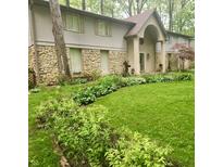 Ranch style home with stone accents and a manicured lawn at 4140 Melbourne Rd, Indianapolis, IN 46228