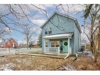 Charming light blue two-story house with a green door and small front porch at 5645 E 16Th St, Indianapolis, IN 46218