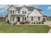 Two-story farmhouse with stone and white siding, landscaping, and a welcoming front porch at 16222 Browning Ct, Fishers, IN 46037