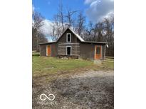 Rustic log cabin home with a metal roof and orange doors at 5967 S Lick Creek Rd, Morgantown, IN 46160