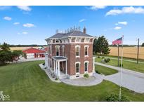 Aerial view of a brick home with a large lawn and outbuildings at 7955 W 400 N, Boggstown, IN 46110