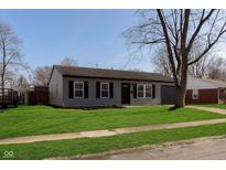 Gray house with black shutters, a nicely landscaped lawn, and a one-car garage at 2707 Aurie Dr, Indianapolis, IN 46219