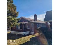 Brick home with blue siding, a covered porch, and a well-maintained lawn at 3949 English Ave, Indianapolis, IN 46201