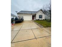 Beige house with a two-car garage and a well-maintained lawn at 8045 Retreat Ln, Indianapolis, IN 46259