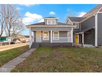 Charming gray house with a white porch and well-maintained lawn at 1101 W Roache St, Indianapolis, IN 46208